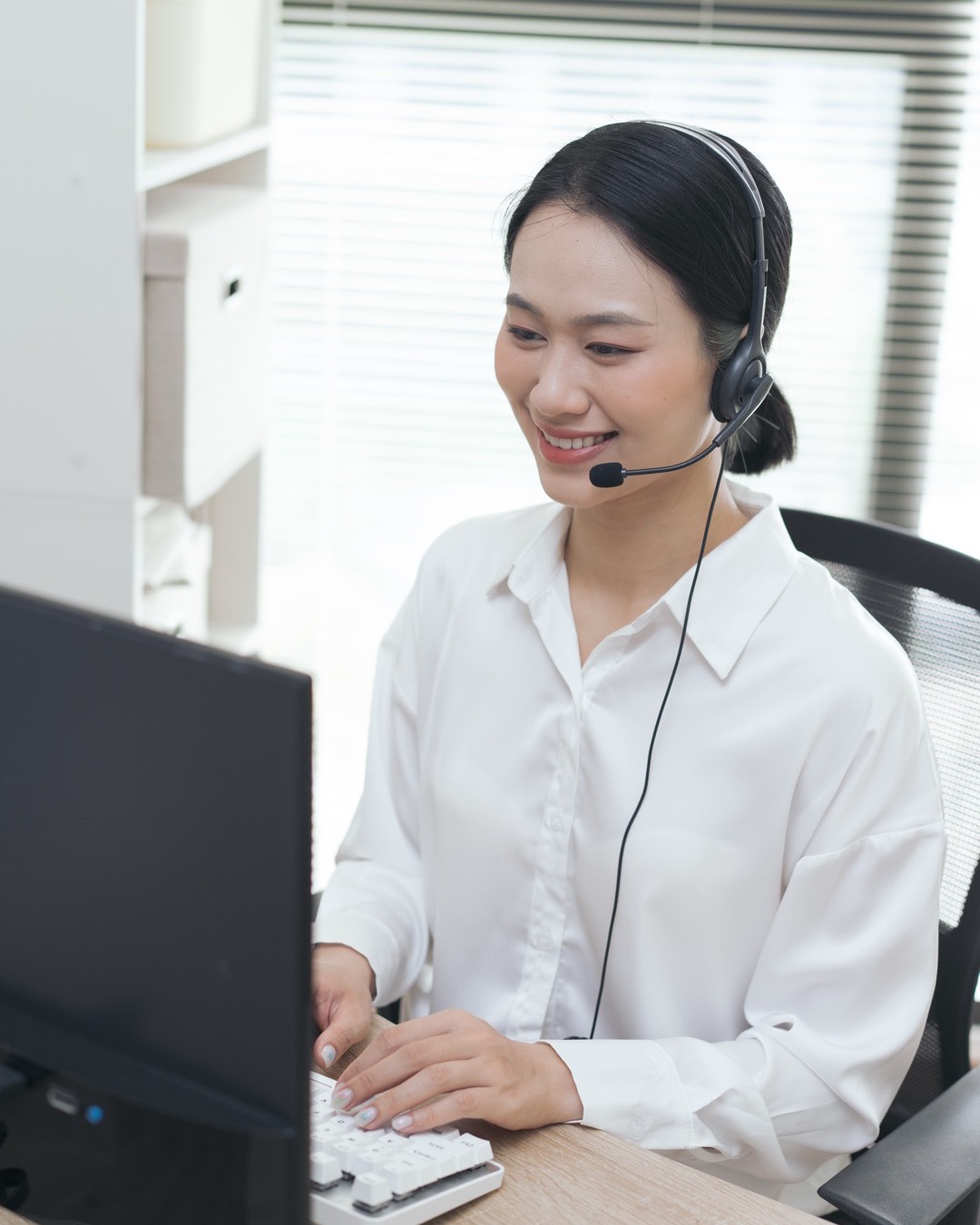 Nhân viên chăm sóc khách hàng đeo tai nghe làm việc